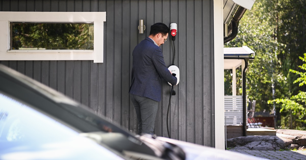 Homeowner plugging in an electric vehicle charger at home