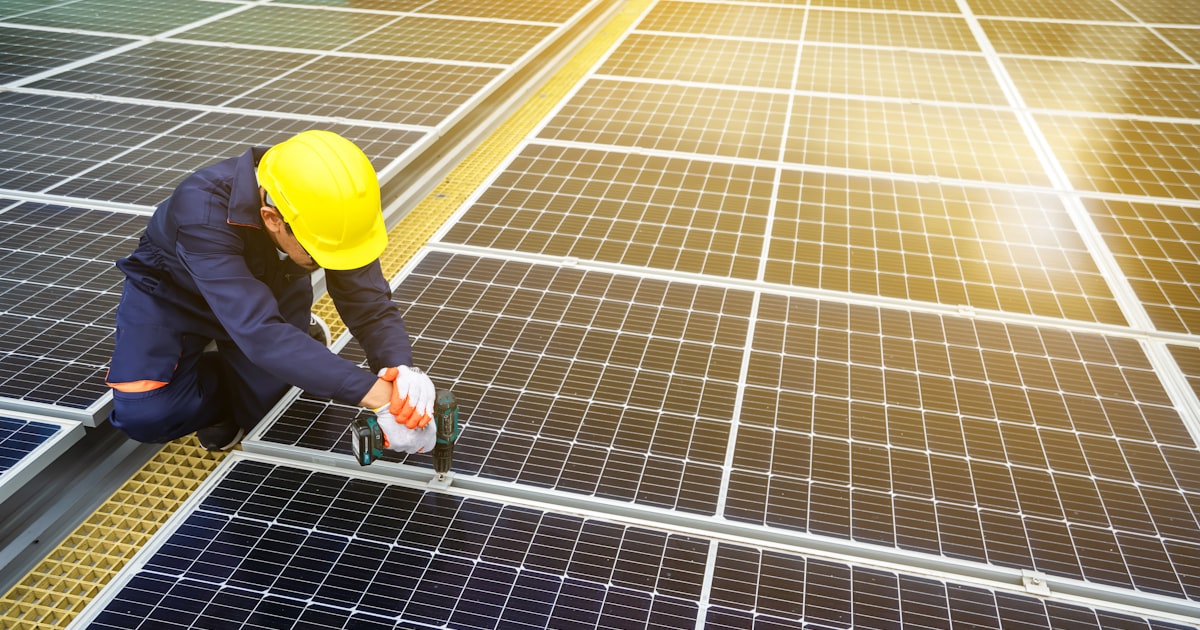 Certified installer fitting solar panels on a roof